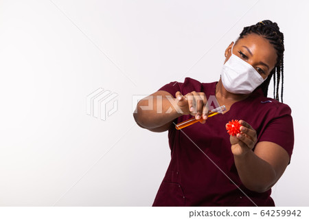 Covid-19, Vaccine development , outbreak and medicine concept - Doctor in medical protective mask holding a model of coronavirus and test tube on white background with copy space. Covid-19, Vaccine development , outbreak and medicine concept - Doctor in medical protective mask holding a model of coronavirus and test tube on white background with copy space. 64259942