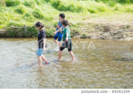 Elementary school students playing in the river 64261284