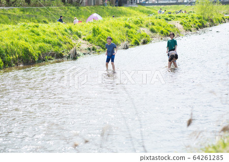 Elementary school students playing in the river 64261285