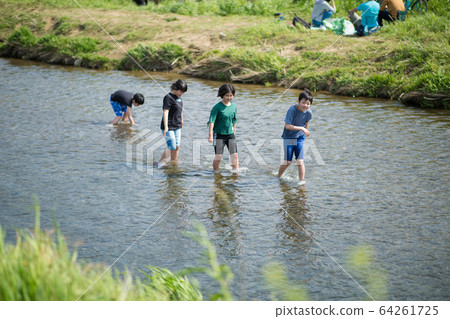 Elementary school students playing in the river Elementary school students playing in the river 64261725