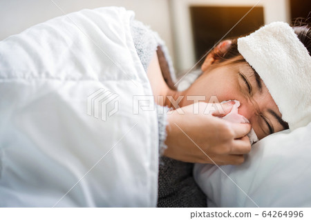 Sick asian woman have hight fever flu and sneezing Sick asian woman have hight fever flu and sneezing 64264996