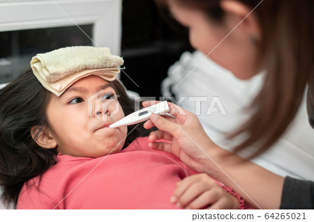Asian mother measuring temperature girl with 64265021