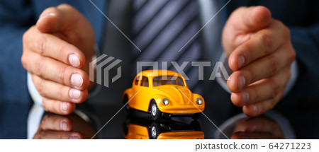 Male arm in suit and tie cover yellow toy car 64271223
