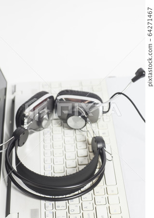 Headset on laptop computer keyboard.Communication 64271467
