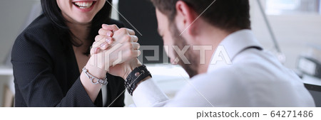 Woman and man in suit hold hands in wrestle Woman and man in suit hold hands in wrestle 64271486
