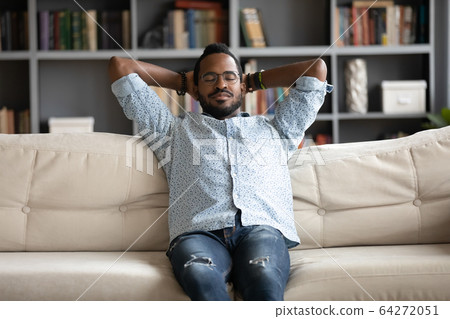 Young peaceful biracial man sleeping on comfortable sofa. Young peaceful biracial man sleeping on comfortable sofa. 64272051