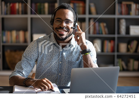 Happy young african american man wearing headset, looking at camera. Happy young african american man wearing headset, looking at camera. 64272451