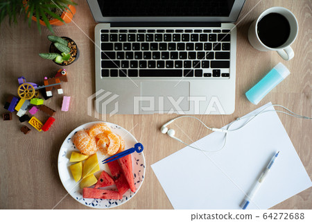 Top view of laptop on the wooden desk with stationaries and coffee with mixed fruit. Work from home. Quarantine at home 64272688