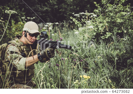 A military man or airsoft player in a camouflage 64273082