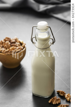 Vegan milk from walnuts on dark background, alternative plant based milk. 64273914