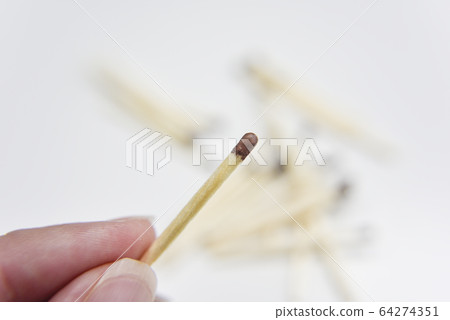 wooden match in the hand with matches on the white 64274351
