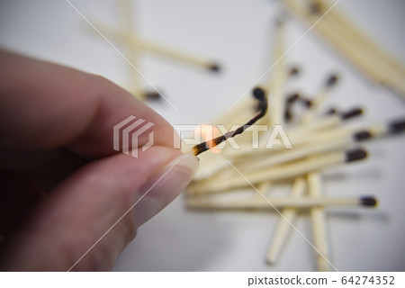 Burning wooden match in the hand with matches on 64274352