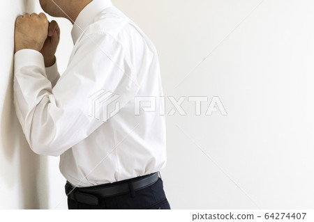 Men wearing shirts depressed by the wall Men wearing shirts depressed by the wall 64274407