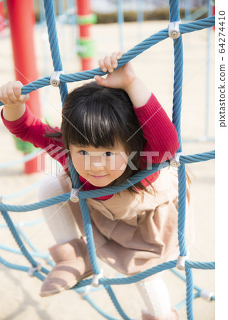 Girl playing with play equipment Girl playing with park 64274410