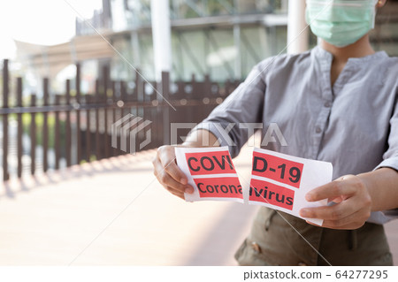 The women hand holding covid19 paper make a symbol fight in disaster covid19, and wearing the mask The women hand holding covid19 paper make a symbol fight in disaster covid19, and wearing the mask 64277295