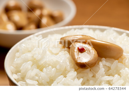Garlic pickled in soy sauce on rice. 64278344