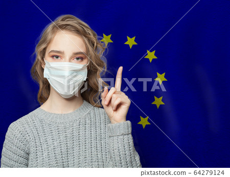 Woman in medical mask pointing up against EU flag Woman in medical mask pointing up against EU flag 64279124