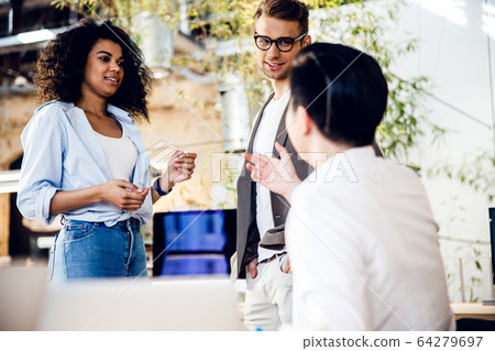 Business colleagues are discussing something at work 64279697