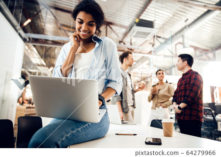 Charming young woman working on laptop in office Charming young woman working on laptop in office 64279966