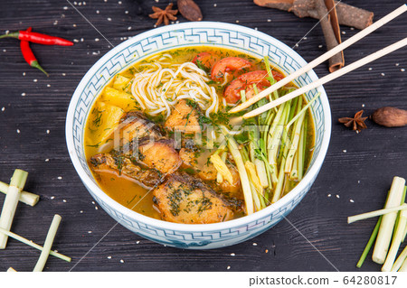 Wok soup with trout, tomatoes, onion feathers and chopped greens 64280817