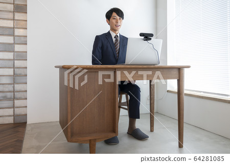 A young man heading for a laptop with a webcam online interview video chat image 64281085