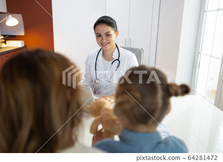 Beautiful female doctor speaking with mum of little patient in clinic 64281472