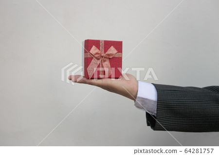 Businessman holds out the gift box ,isolated background Promotions and bonuses. Getting clients interested. Best offers. Businessman holds out the gift box ,isolated background Promotions and bonuses. Getting clients interested. Best offers. 64281757