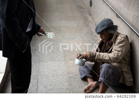 Businessman give money to pity homeless 64282109