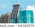 3 Tall Buildings with buildings in the middle higher than the blue sky 64282676