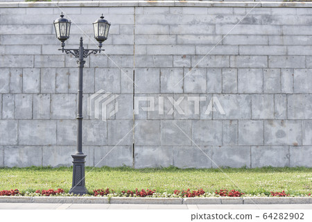 vintage lightpost near the grey wall and green vintage lightpost near the grey wall and green 64282902