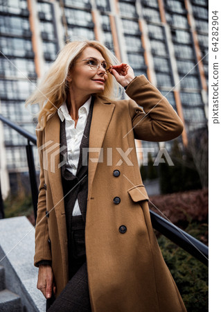 Relaxed woman standing near a stair railing Relaxed woman standing near a stair railing 64282904