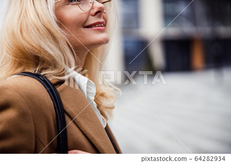 Blonde middle-aged female wearing a cashmere coat 64282934