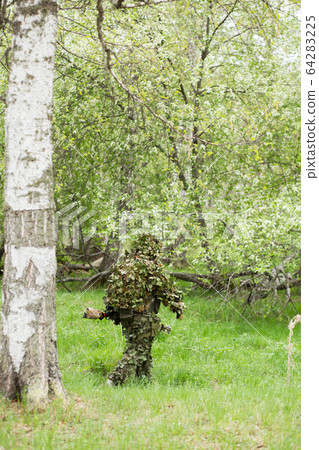 Camouflaged sniper in the forest Camouflaged sniper in the forest 64283225