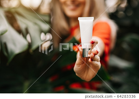 Beautiful woman holding beauty product Beautiful woman holding beauty product 64283336