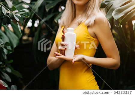 Beautiful woman holding beauty product Beautiful woman holding beauty product 64283337