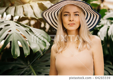 Blonde woman in sun hat Blonde woman in sun hat 64283339