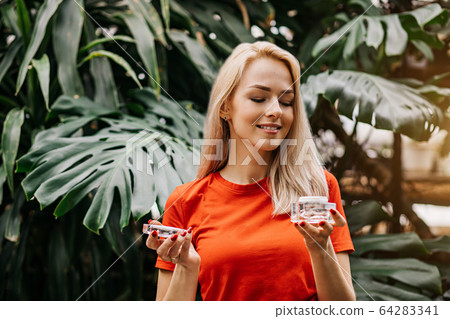 Beautiful woman holding beauty product Beautiful woman holding beauty product 64283341