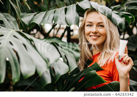 Beautiful woman holding beauty product Beautiful woman holding beauty product 64283342