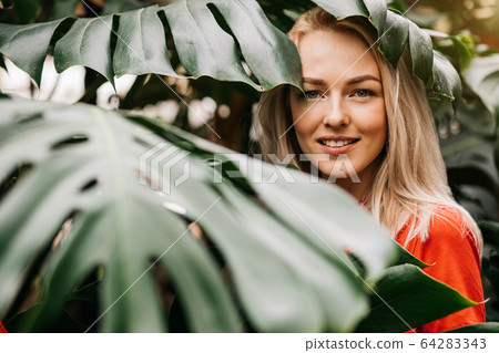 Blonde woman in tropical forest 64283343