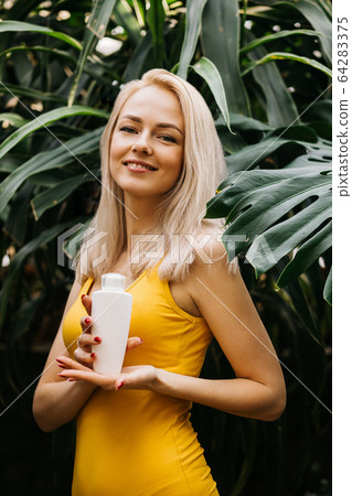 Beautiful woman holding beauty product 64283375