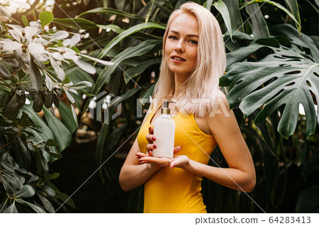 Beautiful woman holding beauty product Beautiful woman holding beauty product 64283413