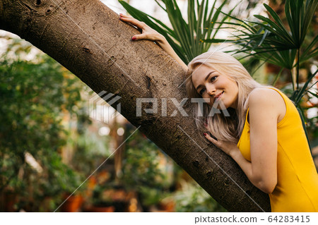 Woman in swimsuit on tropical plants background Woman in swimsuit on tropical plants background 64283415