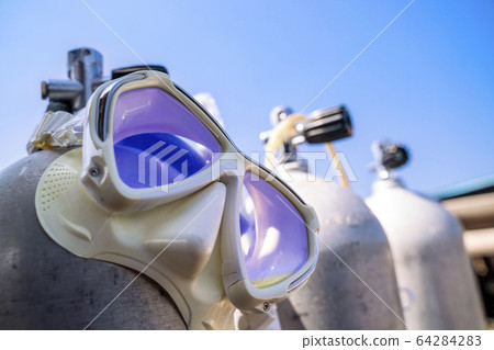A diving mask hanging on the oxygen tank for scuba 64284283