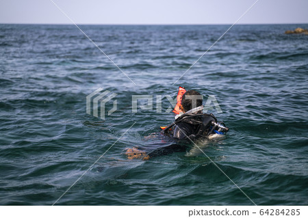 An Asian diving man look forward to the coast line 64284285