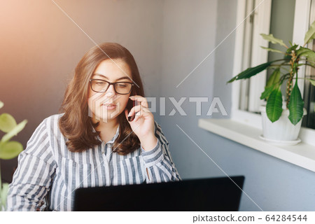 beautiful girl on a laptop working at home 64284544
