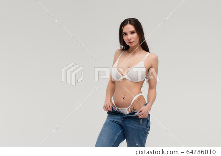 Alluring woman in white lingerie and jeans with Alluring woman in white lingerie and jeans with 64286010