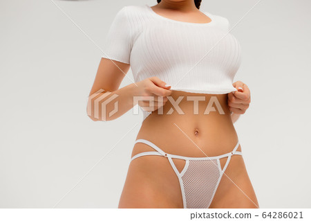 Faceless gorgeous woman with hands on thighs 64286021