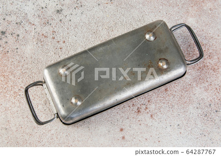 Old Soviet brass syringe sterilizer on concrete 64287767