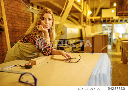 attractive professional woodworker during work in factory attractive professional woodworker during work in factory 64287880