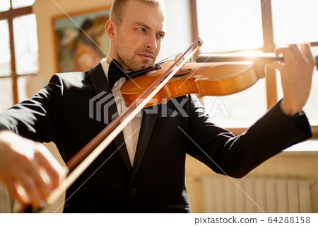 young caucasian violinist play classical instrument 64288158